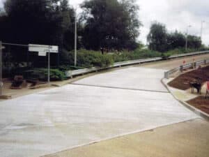 New concrete access road with a crash barrier