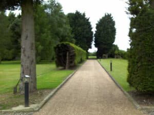 Long estate drive lined with lamps and conifers