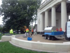 Hot tar being sprayed at a pillared building forecourt