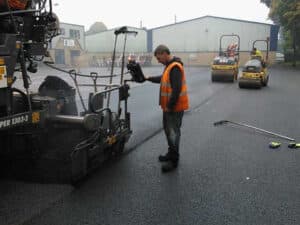 Paving crew laying tarmac in a business park carpark